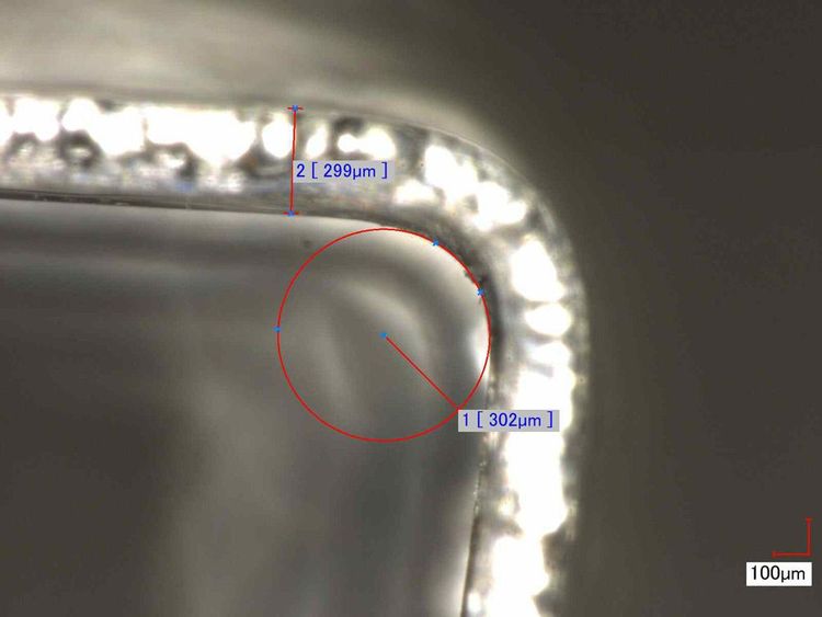 Micro-section of the bend. Strip thickness about 299 µm, inner bend radius about 302 µm, i.e. roughly 1:1 to the material thickness. Scale 100 µm.